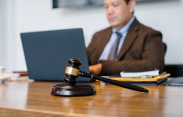 Agavel sitting on a desk with a person using a laptop in the background